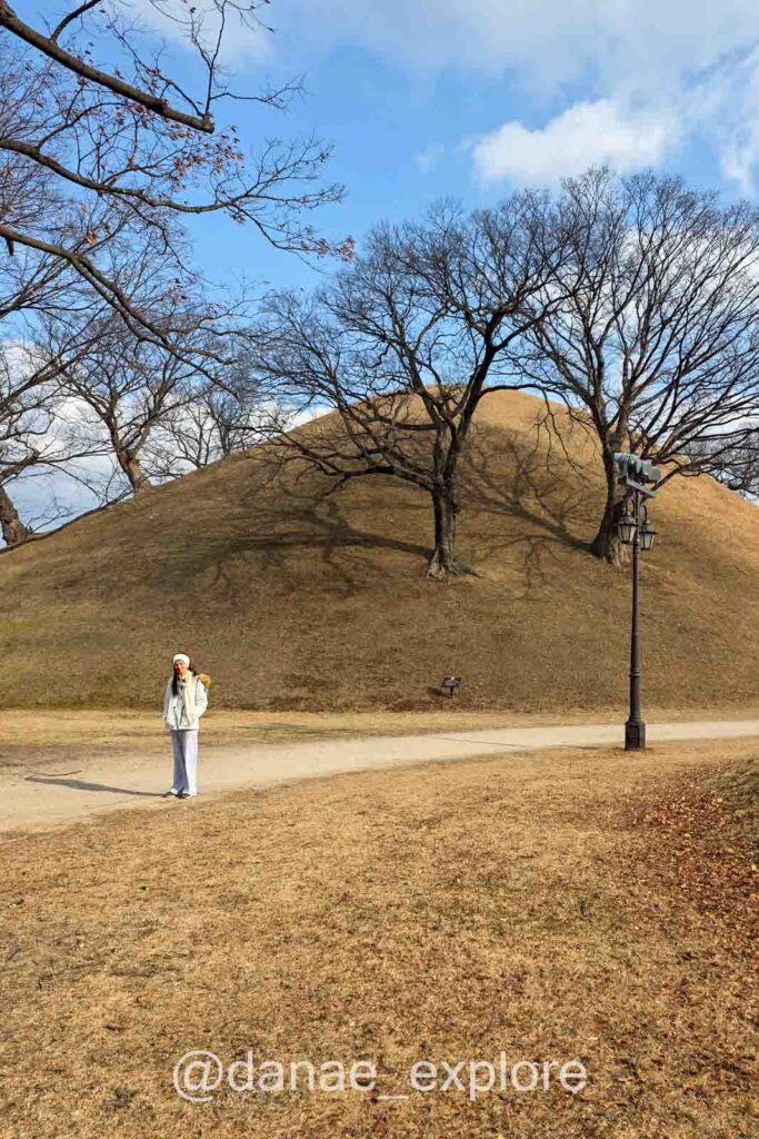 Menina caminha entre tumbas da dinastia Silla, em forma de colinas cobertas de grama, em Gyeongju
