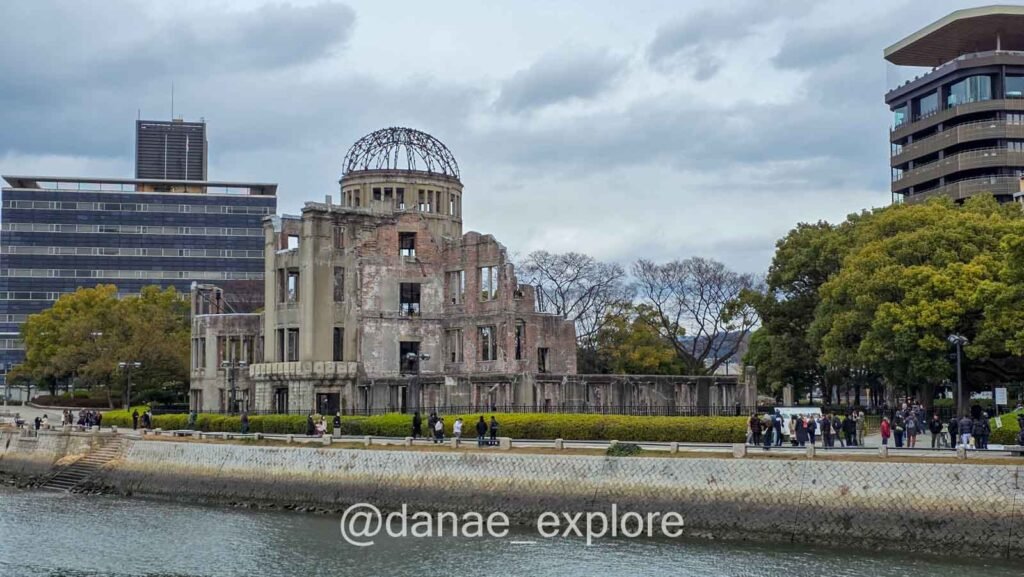 **Atomic Bomb Dome in Hiroshima, a preserved brick ruin left as it was after the atomic bombing, on a sunny day with some clouds**
