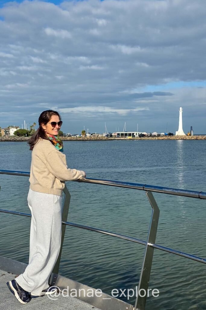Eu, com calça e blusa de lã, no pier de St. Kilda, Melbourne