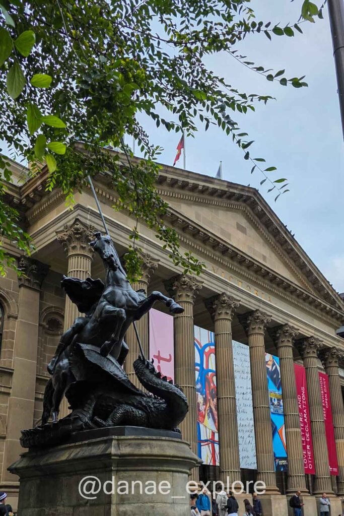 Edifício da State Library Victoria, em primeiro plano estátua de São Jorge e o dragão