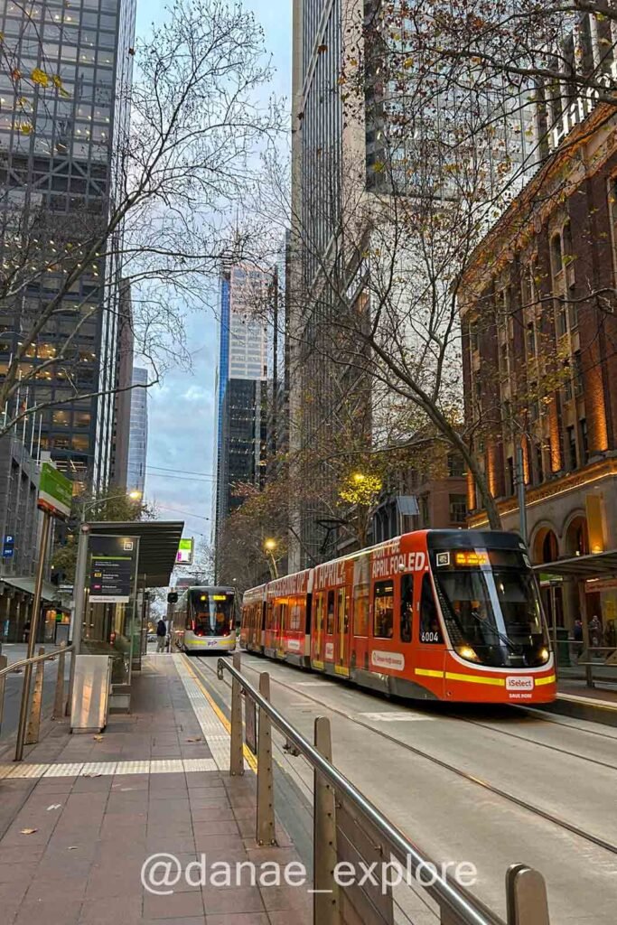 Rua no CBD de Melbourne com tram vermelho, a melhor forma de se locomover pelo centro da cidade